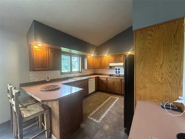 952 Chestnut Ave, Highwood, MT 59450 - kitchen with black appliances, a peninsula, decorative backsplash, under cabinet range hood, and vaulted ceiling