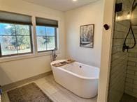 777 Aspen Grove St, Whitefish, MT 59937 - bathroom featuring a freestanding tub and a tile shower