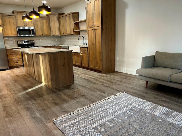 777 Aspen Grove St, Whitefish, MT 59937 - kitchen with appliances with stainless steel finishes, dark wood-style flooring, open shelves, tasteful backsplash, and a kitchen island