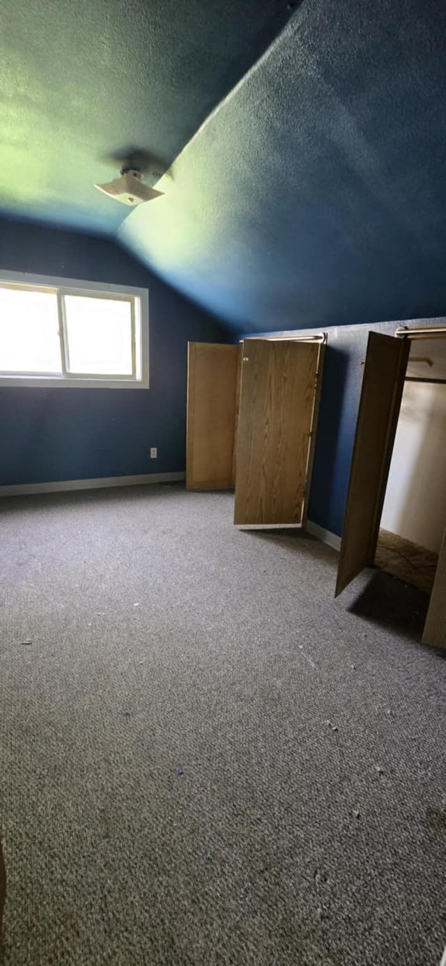 915 3rd Ave SW, Great Falls, MT 59404 - unfurnished bedroom featuring vaulted ceiling, a textured ceiling, and carpet flooring