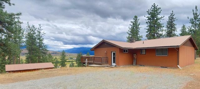 9 Cross Ln, Plains, MT 59859 - view of property exterior featuring a metal roof, a deck with mountain view, and gravel driveway