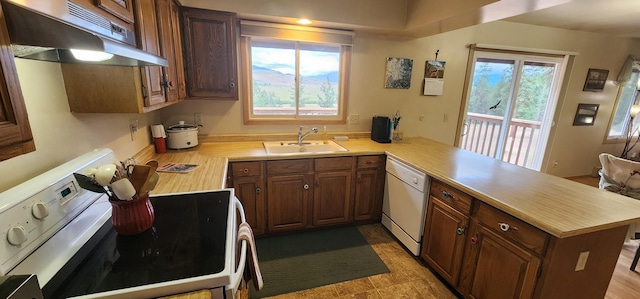 9 Cross Ln, Plains, MT 59859 - kitchen with white appliances, under cabinet range hood, a peninsula, and light countertops