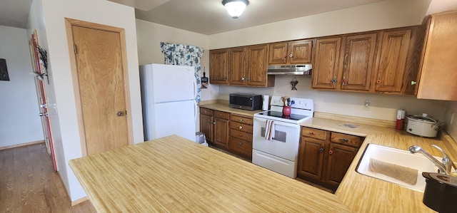 9 Cross Ln, Plains, MT 59859 - kitchen with white appliances, under cabinet range hood, light countertops, and brown cabinets