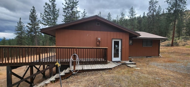 9 Cross Ln, Plains, MT 59859 - view of front of home with a wooden deck, a forest view, and a metal roof