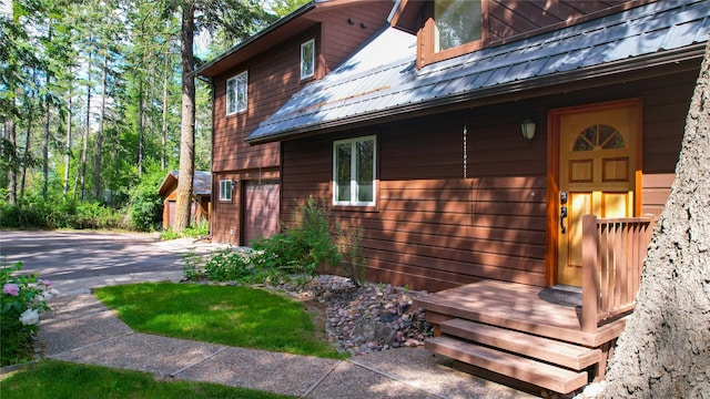 251 Elk Trl, Whitefish, MT 59937 - view of home's exterior with a metal roof, concrete driveway, and an attached garage
