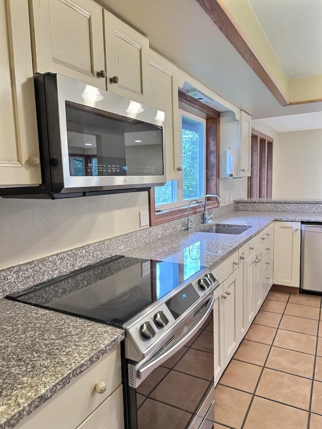 251 Elk Trl, Whitefish, MT 59937 - kitchen featuring appliances with stainless steel finishes, white cabinets, light stone counters, and light tile patterned flooring