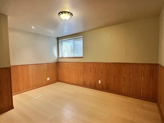 251 Elk Trl, Whitefish, MT 59937 - unfurnished room featuring wainscoting, wood finished floors, wood walls, and a textured ceiling