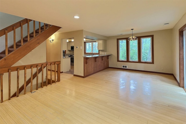 251 Elk Trl, Whitefish, MT 59937 - kitchen with stainless steel range oven, light wood finished floors, white cabinetry, a peninsula, and recessed lighting