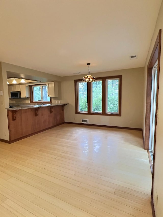 251 Elk Trl, Whitefish, MT 59937 - kitchen with stainless steel microwave, plenty of natural light, and light wood-style floors