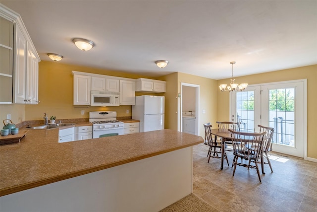 341 Northgate Loop, Helena, MT 59602 - kitchen with white appliances, a peninsula, a chandelier, white cabinets, and hanging light fixtures