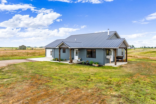 44 Kamloops Rd, Power, MT 59468 - single story home featuring a front yard, driveway, a metal roof, a standing seam roof, and covered porch