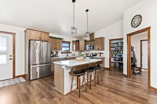 44 Kamloops Rd, Power, MT 59468 - kitchen with stainless steel appliances, vaulted ceiling, dark wood-type flooring, a kitchen island, and a kitchen breakfast bar