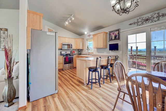 5835 Winter Wheat Dr, Helena, MT 59602 - kitchen with stainless steel appliances, light brown cabinetry, a peninsula, lofted ceiling, and a chandelier