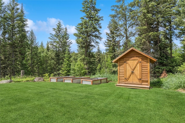 220 Cliff Creek Rd, Whitefish, MT 59937 - view of grassy yard with a garden, a storage shed, and a wooded view
