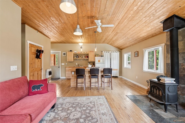 220 Cliff Creek Rd, Whitefish, MT 59937 - living room featuring a wood stove, wood ceiling, lofted ceiling, light wood finished floors, and a ceiling fan
