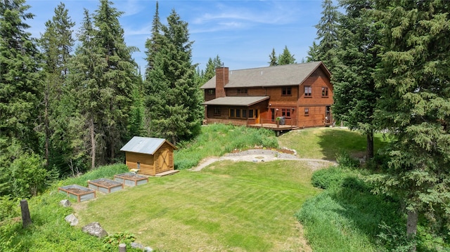 220 Cliff Creek Rd, Whitefish, MT 59937 - view of grassy yard featuring a shed, a wooden deck, and a garden