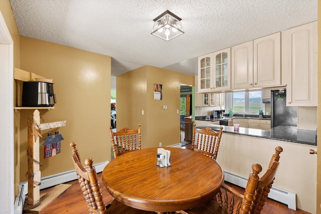 149 Meadow Vista Ln, Deer Lodge, MT 59722 - dining room featuring a textured ceiling, wood finished floors, and baseboard heating