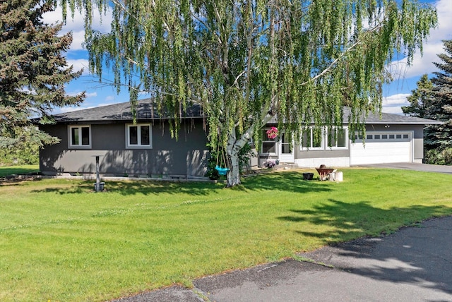 149 Meadow Vista Ln, Deer Lodge, MT 59722 - view of front of house with an attached garage, a front yard, and stucco siding