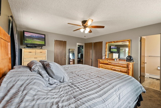 149 Meadow Vista Ln, Deer Lodge, MT 59722 - bedroom with a baseboard heating unit, ceiling fan, a textured ceiling, and multiple closets