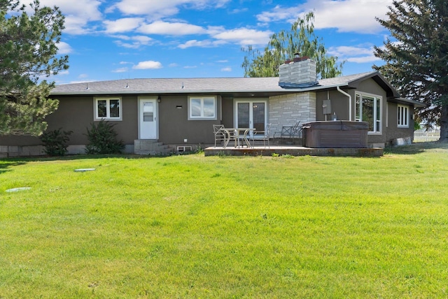 149 Meadow Vista Ln, Deer Lodge, MT 59722 - rear view of house with a hot tub, entry steps, a lawn, and a chimney