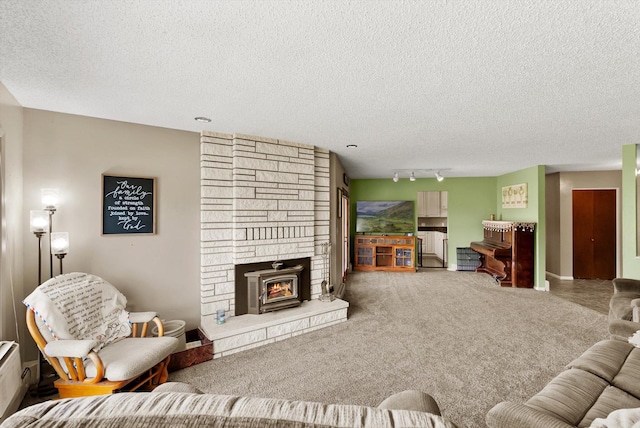 149 Meadow Vista Ln, Deer Lodge, MT 59722 - living area with a textured ceiling, a stone fireplace, rail lighting, and carpet floors