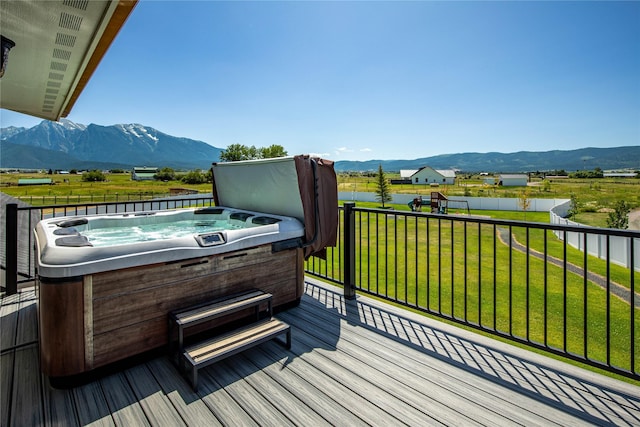 60951 Sparky Dr, Saint Ignatius, MT 59865 - wooden terrace featuring a hot tub, a mountain view, and a playground