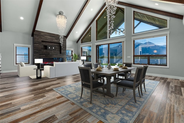 60951 Sparky Dr, Saint Ignatius, MT 59865 - dining space with beam ceiling, a large fireplace, high vaulted ceiling, and wood finished floors