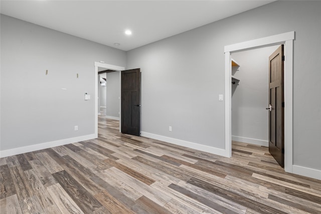 60951 Sparky Dr, Saint Ignatius, MT 59865 - unfurnished bedroom featuring wood finished floors, a walk in closet, recessed lighting, and a closet