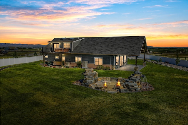 60951 Sparky Dr, Saint Ignatius, MT 59865 - back of property featuring a fire pit, a fenced backyard, roof with shingles, and a balcony