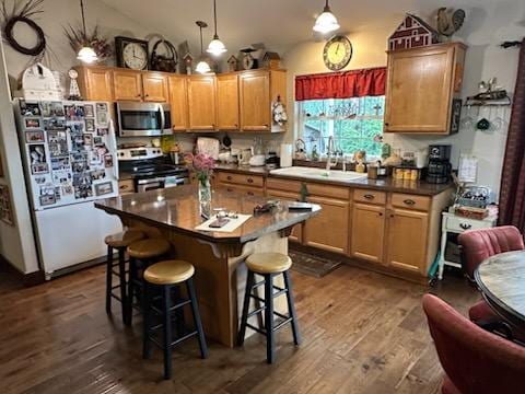 41052 Canyon View Dr, Polson, MT 59860 - kitchen featuring appliances with stainless steel finishes, a kitchen bar, dark wood-style flooring, vaulted ceiling, and dark countertops