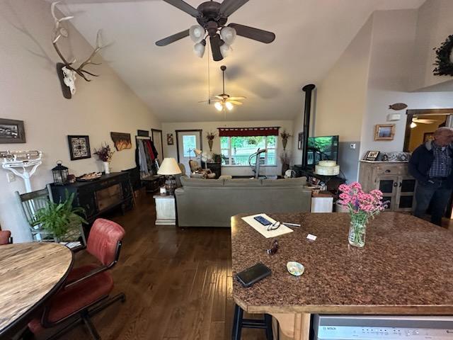 41052 Canyon View Dr, Polson, MT 59860 - dining area with ceiling fan, dark wood-style flooring, high vaulted ceiling, and a wood stove