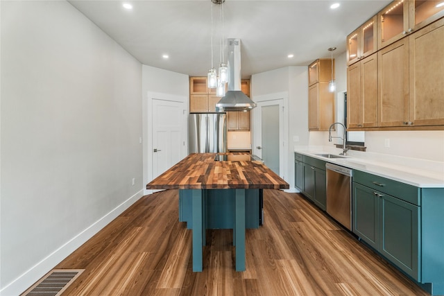 37 S Rodney St, Helena, MT 59601 - kitchen with appliances with stainless steel finishes, wooden counters, wall chimney exhaust hood, dark wood-style flooring, and a kitchen island