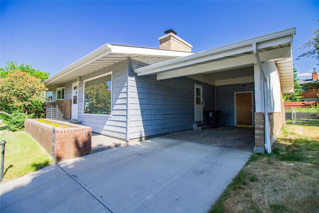 3455 N Hillcrest Dr, Butte, MT 59701 - view of front of home featuring driveway, a chimney, and a carport
