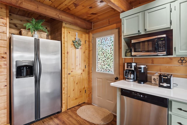 168 Carpenter Ln, Eureka, MT 59917 - kitchen with appliances with stainless steel finishes, a wood ceiling with exposed beams, wood finished floors, light countertops, and wood walls