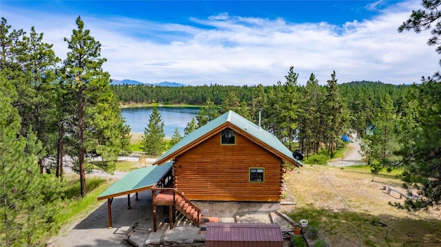 168 Carpenter Ln, Eureka, MT 59917 - back of house with a view of trees, log siding, and a water and mountain view