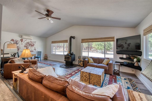 409 Mill Creek Rd, Hamilton, MT 59840 - living area with plenty of natural light, vaulted ceiling, a wood stove, an AC wall unit, and ceiling fan