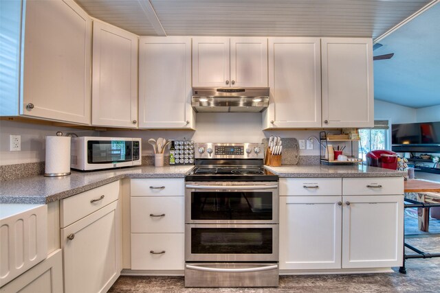 409 Mill Creek Rd, Hamilton, MT 59840 - kitchen featuring range with two ovens, under cabinet range hood, white cabinetry, and vaulted ceiling