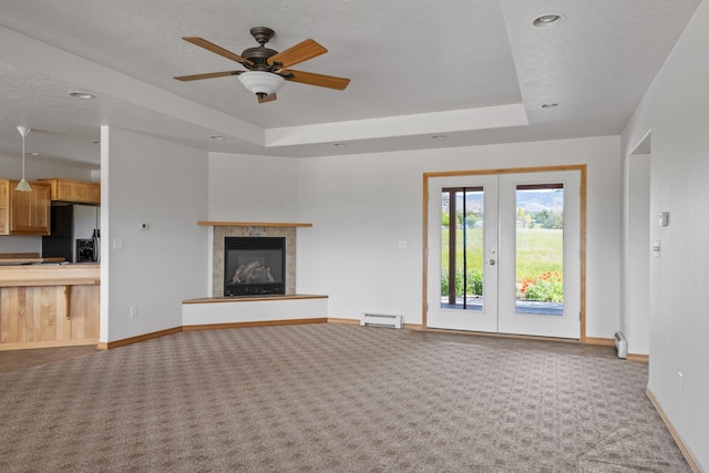 1228 Nordheim Ln, Corvallis, MT 59828 - unfurnished living room featuring carpet floors, a tray ceiling, recessed lighting, and a baseboard radiator