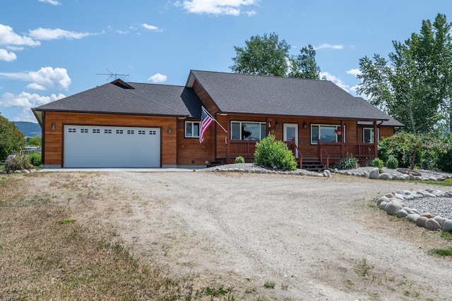 1228 Nordheim Ln, Corvallis, MT 59828 - chalet / cabin featuring dirt driveway, covered porch, an attached garage, and roof with shingles