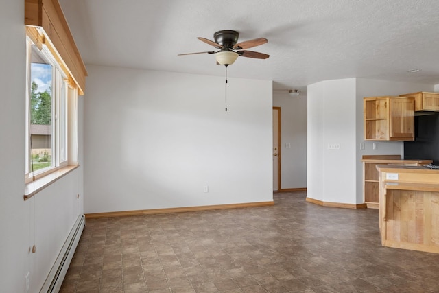 1228 Nordheim Ln, Corvallis, MT 59828 - kitchen with baseboard heating, a ceiling fan, fridge, light brown cabinets, and stone finish floors