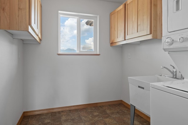 1228 Nordheim Ln, Corvallis, MT 59828 - laundry area featuring stacked washer / drying machine, cabinet space, and stone finish floors