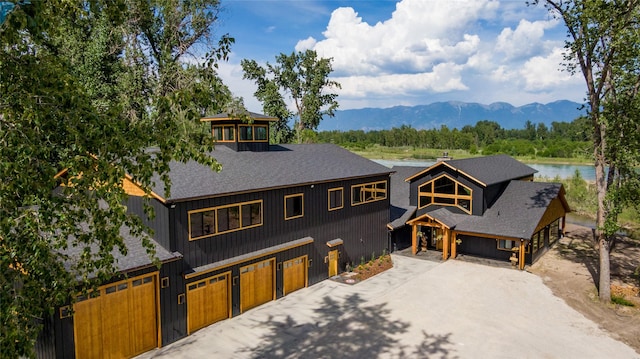 600 Ringneck Dr, Kalispell, MT 59901 - chalet / cabin with a shingled roof, driveway, and a water and mountain view