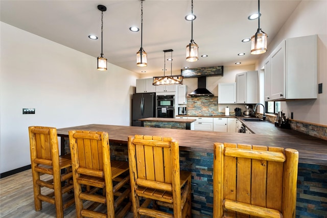 600 Ringneck Dr, Kalispell, MT 59901 - kitchen with freestanding refrigerator, decorative backsplash, wall chimney exhaust hood, dark countertops, and recessed lighting