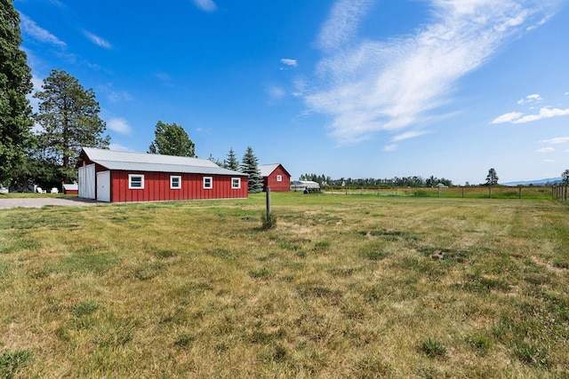 1380 Lower Valley Rd, Kalispell, MT 59901 - view of green lawn featuring a garage, an outdoor structure, an outbuilding, driveway, and a view of countryside