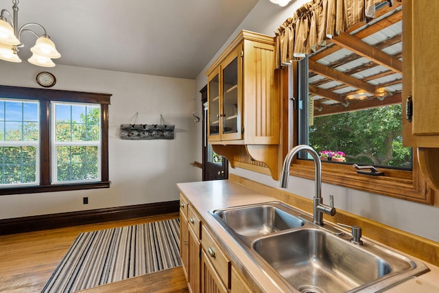 1380 Lower Valley Rd, Kalispell, MT 59901 - kitchen with plenty of natural light, wood finished floors, glass insert cabinets, and hanging light fixtures