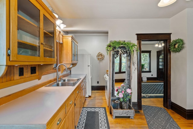 1380 Lower Valley Rd, Kalispell, MT 59901 - kitchen with light countertops, light wood-style flooring, glass insert cabinets, and freestanding refrigerator