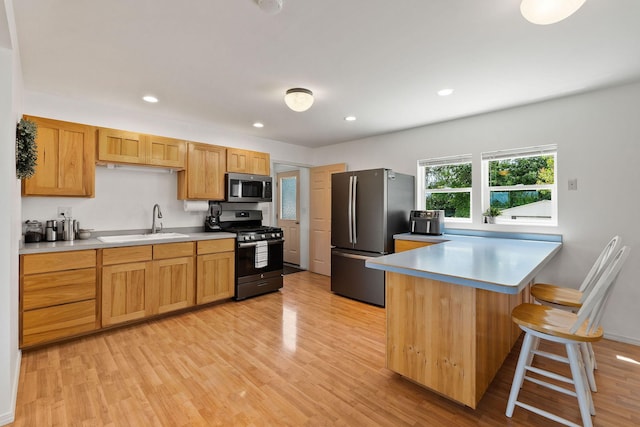1380 Lower Valley Rd, Kalispell, MT 59901 - kitchen featuring stainless steel appliances, light wood-style floors, a peninsula, a kitchen bar, and recessed lighting