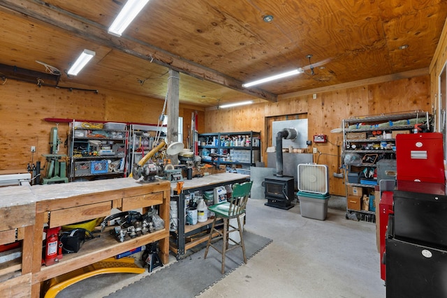 1380 Lower Valley Rd, Kalispell, MT 59901 - miscellaneous room featuring a workshop area, concrete flooring, a wood stove, and wood walls