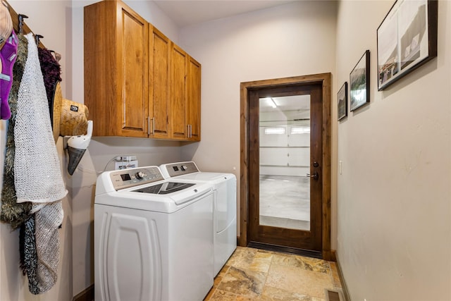 33731 Westview Dr, Bigfork, MT 59911 - washroom with washer and dryer, cabinet space, and light stone finish flooring