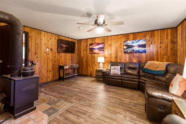 630 Tally Lake Rd, Whitefish, MT 59937 - living room featuring a wood stove, a ceiling fan, wood walls, and wood finished floors